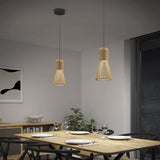 A modern dining area with a wooden table set for four, black chairs, two pendant lights hanging above, a plant in the corner, a black-and-white abstract artwork on the wall, and large window blinds.