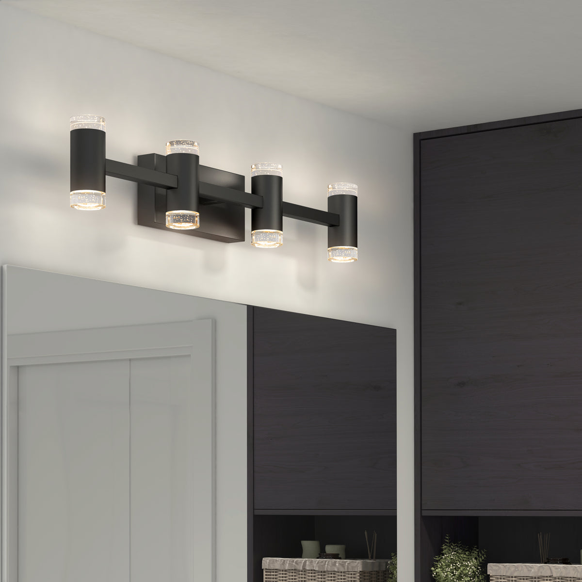 The Artika Mist modern LED bathroom vanity light 5 CCT, a sleek black four-light fixture with adjustable color temperatures, is mounted above a large mirror in a contemporary bathroom with dark cabinets and a white ceiling.