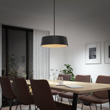 A modern dining room with a wooden table, six brown chairs, a black pendant light, potted plants, framed art on pale walls, and a large window showing a cityscape at night.