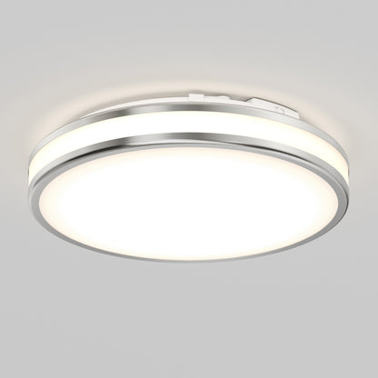 The Artika Hemisphere 15 in. LED flush mount light offers 5 CCT adjustable brightness with a modern round design, brushed metal rim, and frosted diffuser—ideal for stylish, functional bathroom lighting on a light gray ceiling.