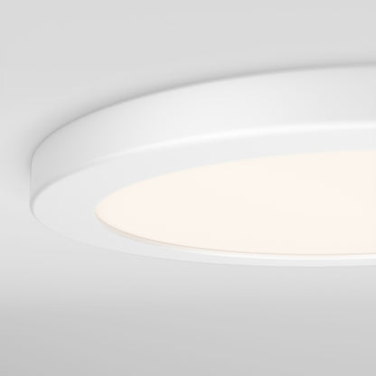 A close-up of the Artika Europa Disk 9 in. LED modern flush mount light, illuminated in a round, white design against a smooth light gray ceiling. Features 3 selectable color temperatures (CCT).