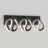 A modern wall-mounted light fixture with three black loops, each outlined with integrated LED lights, attached to a rectangular black base against a plain light gray background.
