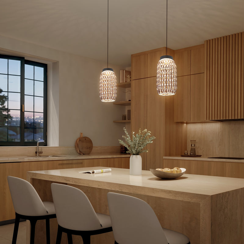 Modern kitchen with light wood cabinets, a marble island with three white chairs, and Artika Benson Mini LED pendant lights (5 CCT, adjustable color temperature). A vase of flowers and apples decorates the island under warm ambient lighting.