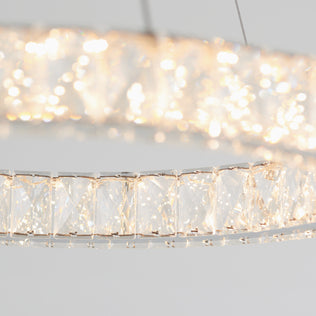 Two Artika Celebrity LED pendant lights with bright, sparkling crystals are suspended on thin wires against a plain light background, highlighting the reflective and shimmering quality of their crystal design.