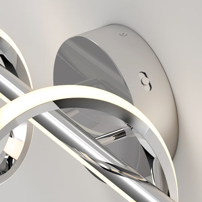 Close-up of the Artika Coda modern LED bathroom vanity light 5 CCT, featuring a sleek chrome finish with curved, glowing elements and a reflective surface set against a neutral background.