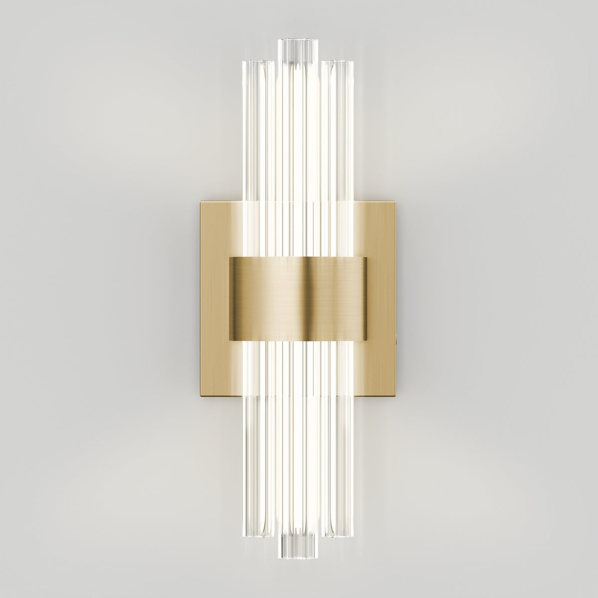 A modern wall sconce with vertical clear glass rods, mounted on a rectangular brass plate, emits bright light against a plain white wall.