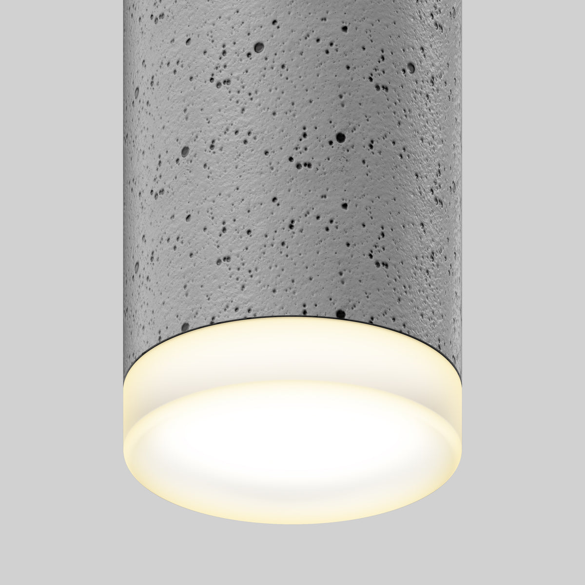 A close-up of the Artika Barden 1-light LED pendant 5 CCT, featuring a cylindrical, textured concrete design and a warm glow from beneath, set against a plain gray background.