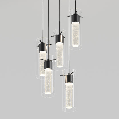 The Artika Essence 5-light LED pendant features sleek cylindrical glass shades with bubble accents, suspended at different heights on black cords against a plain light gray background.