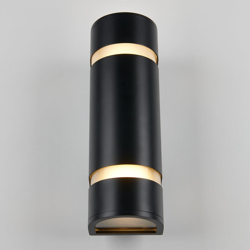 The Artika D4 indoor-outdoor wall light is a modern black cylindrical sconce that emits light from both the top and bottom, shown mounted on a light gray wall.