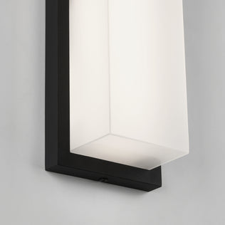 Close-up of the Artika Skeet LED indoor-outdoor light, featuring a rectangular black frame and frosted white glass shade, mounted on a light-colored wall.