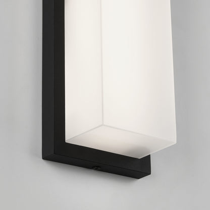 Close-up of the Artika Skeet LED indoor-outdoor light, featuring a rectangular black frame and frosted white glass shade, mounted on a light-colored wall.