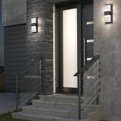 Contemporary entrance with gray stone, metal railings, concrete steps, and a sleek frosted glass door—illuminated by the Artika Mazza Frosted indoor-outdoor LED wall light for stylish, functional lighting.