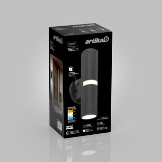 A black rectangular Artika box displays the Groove LED indoor-outdoor wall light. The package shows the cylindrical black fixture, specs, energy ratings, and an image of the light installed by a doorway.