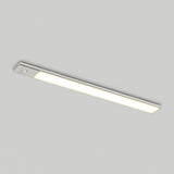 A slim, rectangular LED ceiling light with a white glow is mounted on a plain, light-colored ceiling.