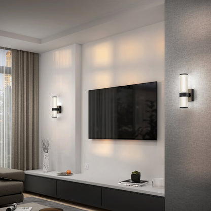 Modern living room with a wall-mounted TV, gray sofa, floor-length curtains, low black and white console with decor, and two Artika Mirado modern LED wall sconces (5 CCT) on either side of the TV.