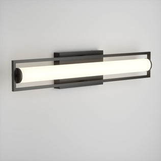 The Artika Rialto modern LED bathroom vanity light 3 CCT features a rectangular black frame with a cylindrical frosted glass shade, offering dimmable, customizable lighting for versatile ambiance.