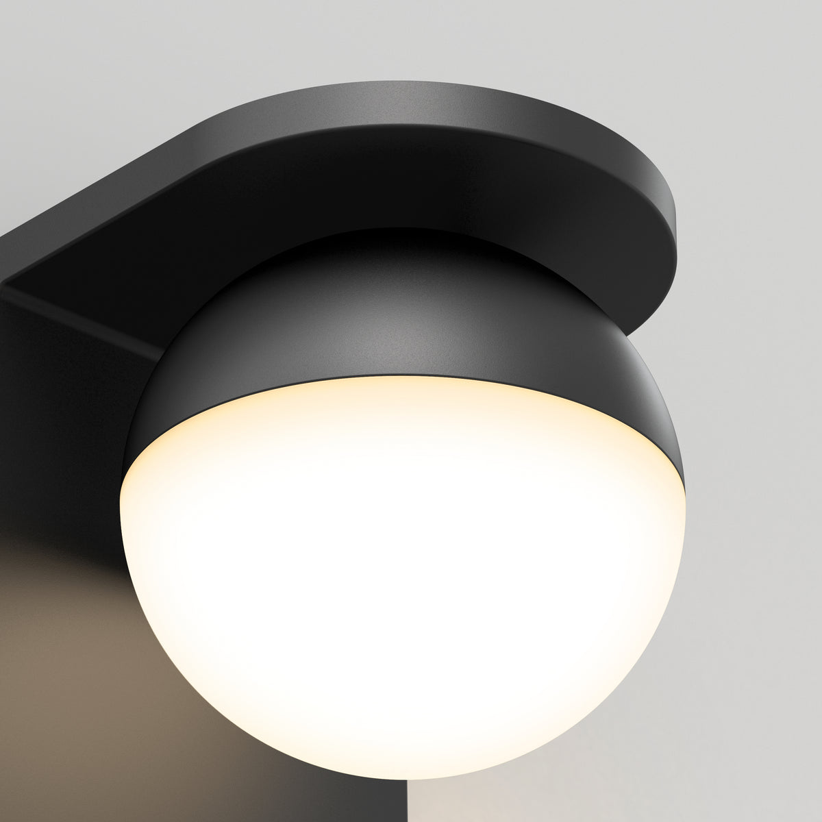 A close-up of the Artika Bloom indoor-outdoor LED wall light 3 CCT, featuring a modern, black, rounded housing with a glowing white circular lamp against a neutral background.