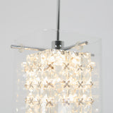 Close-up of a modern hanging pendant light with a geometric crystal design, featuring small star-shaped details and illuminated from within, against a plain light background.