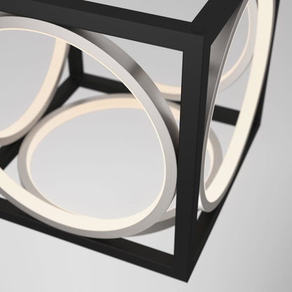 The Astoria LED modern pendant light by Artika showcases a black metal cube framing circular LED rings, creating a sleek, contemporary look against a light gray backdrop.