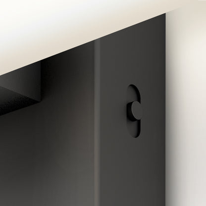Close-up of the Artika Wilton LED modern bathroom vanity light 5 CCT, featuring a black vertical metal beam with an oval slot and round button beneath a white horizontal surface in a minimal, modern setting.