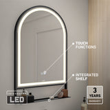 A modern arched mirror with an integrated LED light, touch functions, and a small black shelf. The mirror is mounted on a gray wall above a bathroom counter. A “3 years warranty” label is in the lower right corner.