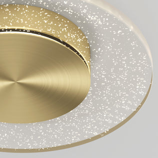 Close-up of the Artika Essence Disk LED flush mount, featuring a brushed gold center and a translucent ring with sparkling bubble-like dots that create a starry effect, set against a neutral light gray background.