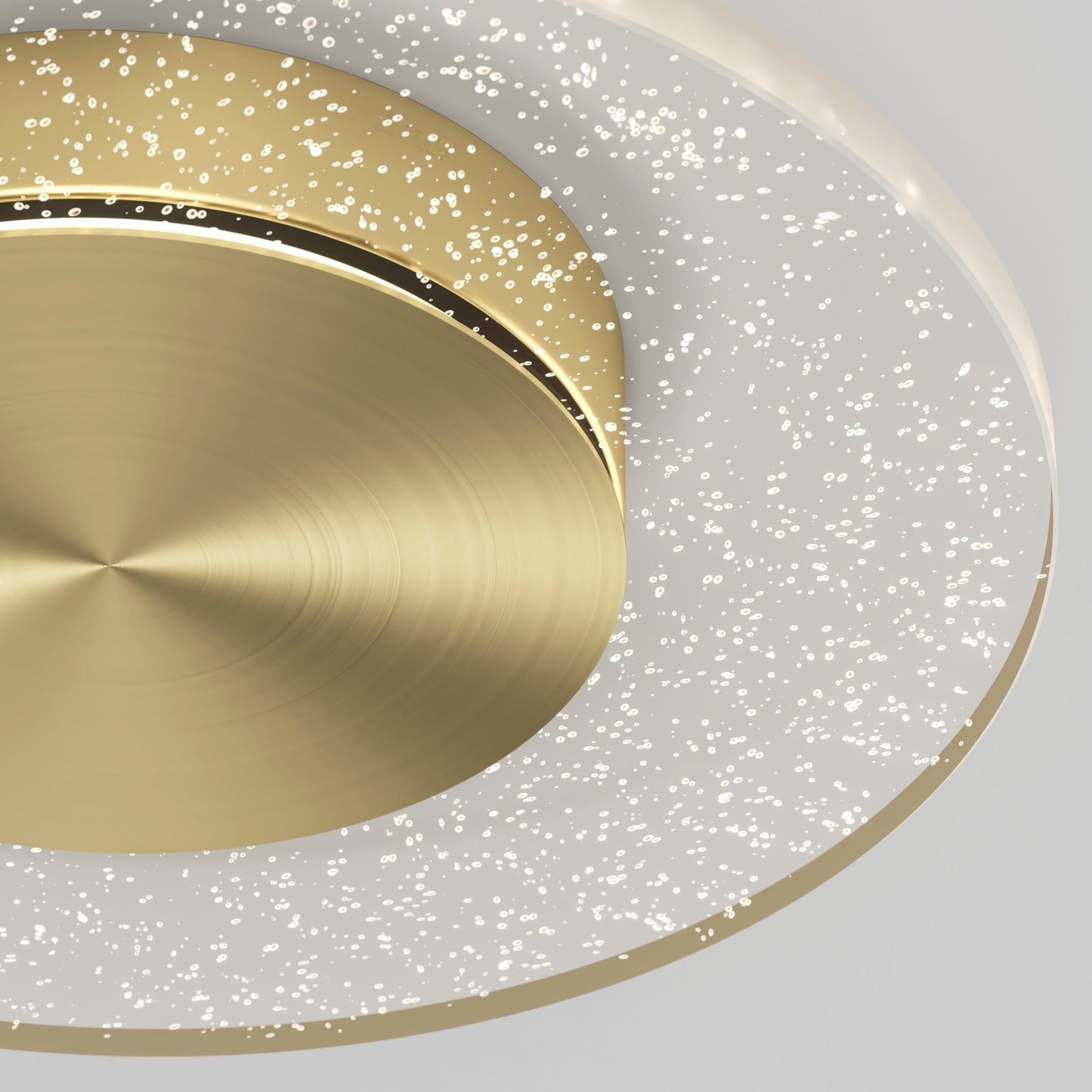 A close-up of the Essence Disk LED flush mount by Artika-CAN-dev shows its modern design with a circular brushed gold center and a translucent glass diffuser ring featuring sparkling bubble-like details.