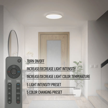 A modern hallway features the Artika Astrid 16.5 in. LED flush mount light (5 CCT) with remote, a wooden door, and a staircase. The remote lets you turn the light on/off, adjust brightness, color temperature, and select color presets.
