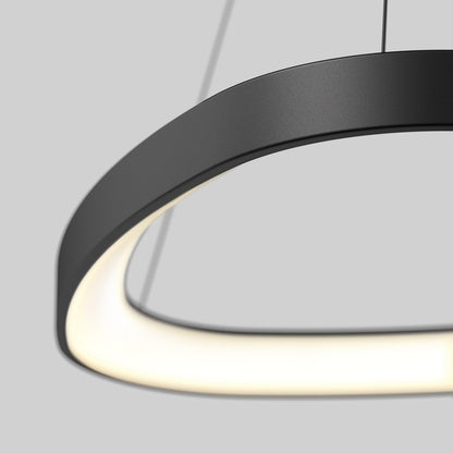 A close-up of the Artika Bjorn modern LED pendant light 5 CCT, featuring a circular black design with a smooth, glowing inner edge, suspended by thin cables against a plain grey background.