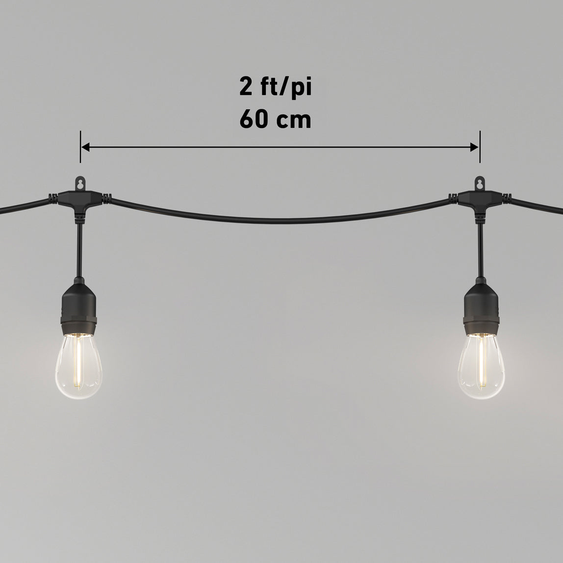 A string of lights with two hanging bulbs spaced 2 feet or 60 cm apart, shown against a plain gray background with the measurement indicated above the bulbs.