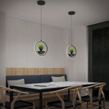 Modern dining area with a marble table, wooden chairs, and a built-in bench. Two circular pendant lights with small potted plants hang above the table. A large window with blinds is on the right wall.