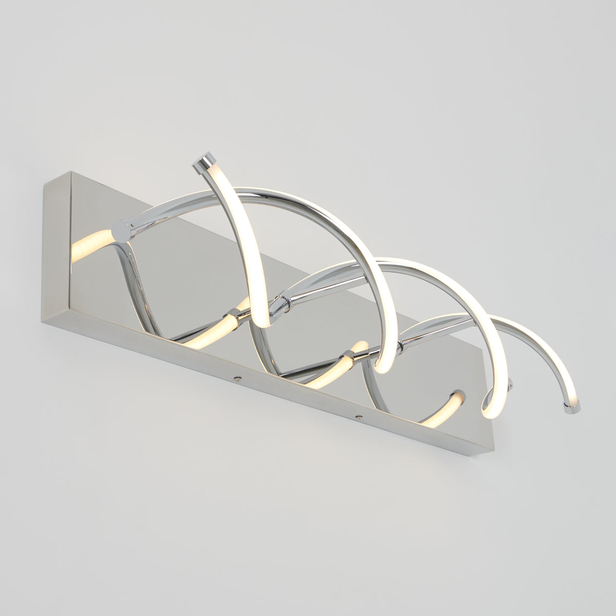 Modern wall light fixture with a rectangular chrome base and three curved LED light bars arranged in an artistic, wave-like design. The fixture is mounted on a plain white wall.
