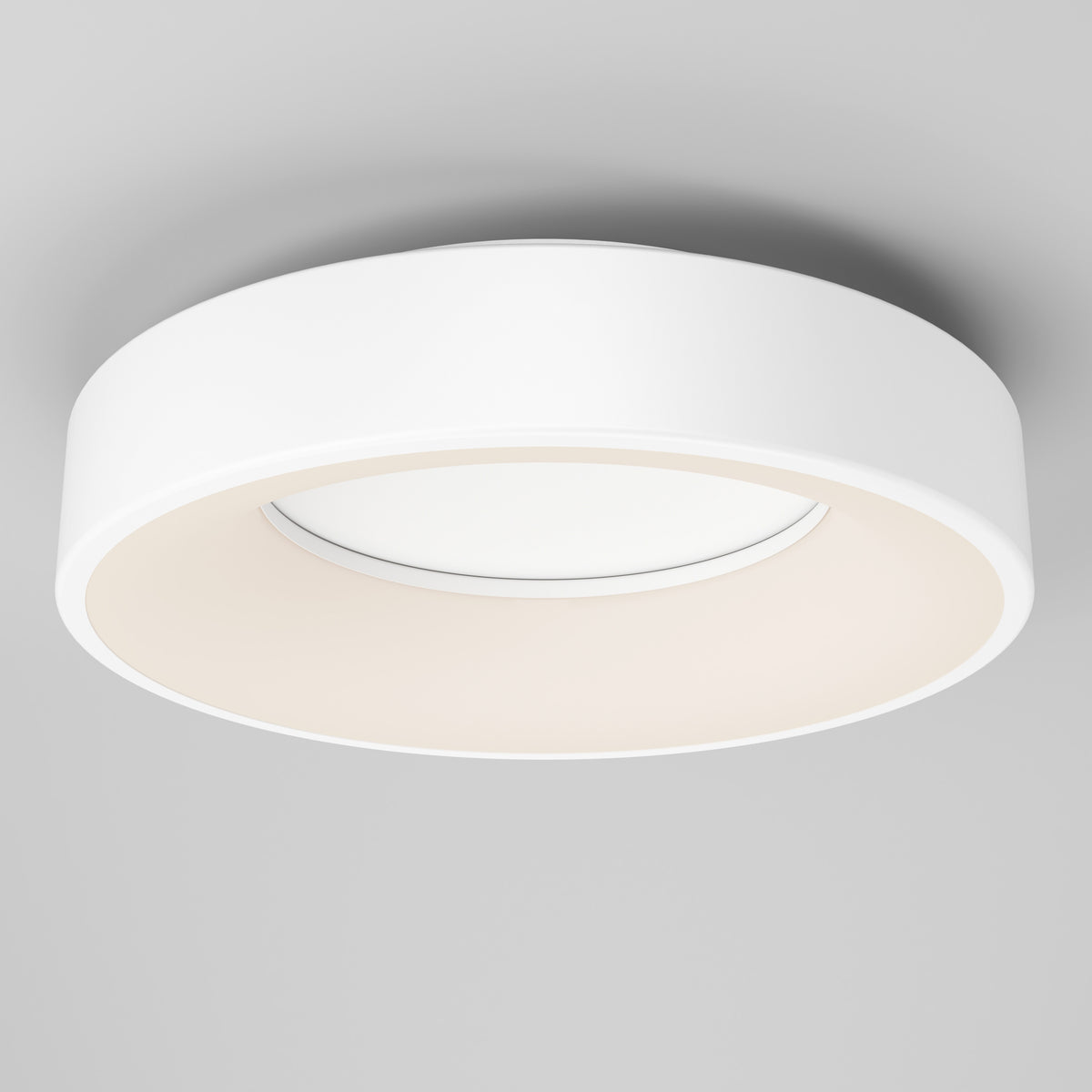 A modern, circular white ceiling light fixture with a minimalist design, mounted on a smooth, light gray ceiling. The light glows softly from the inner rim, creating an even, ambient illumination.