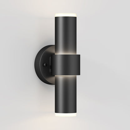 The Artika Dani modern LED indoor-outdoor wall light 5 CCT is a sleek, cylindrical black sconce with up-and-down lighting, mounted on a round base against a white wall.