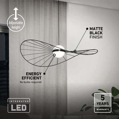 The Artika Tolena LED pendant light 3 CCT features adjustable height, a matte black finish, energy efficiency, and a 5-year warranty. This modern fixture with integrated LED is shown hanging in front of a window and curtain.