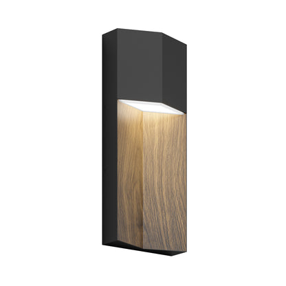 The Artika Howel modern LED indoor-outdoor wall light 5 CCT features a rectangular black frame with a wood-textured accent and a top-positioned light source that shines downward to highlight the wood grain.