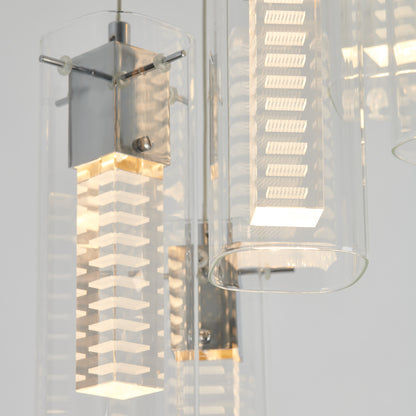 Close-up of the Artika Hologram 5-light LED pendant, featuring rectangular glass coverings and layered geometric diffusers suspended from a metallic mount, emitting a soft, warm glow.