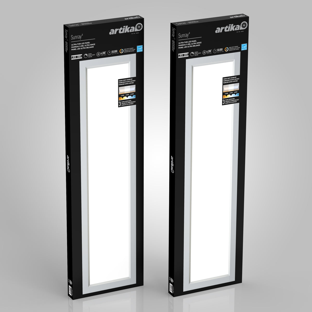 Two rectangular Artika brand Sunray ceiling light panels in black packaging, standing upright against a plain gray background. The boxes feature product details and a window showing the white lights inside.