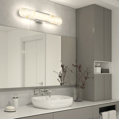 Modern bathroom with gray cabinets, a large mirror, oval sink, and wall-mounted faucet. Above the mirror is the Artika Selena 3 CCT LED bathroom vanity light. A small vase with dried branches decorates the counter.