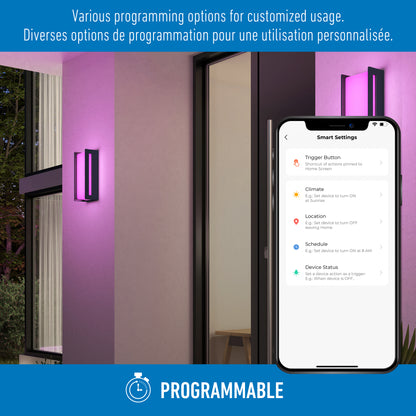 A Ryker smart RGB indoor-outdoor wall light by Artika illuminates a modern entrance in purple. A smartphone displays light settings with English and French programming options. Programmable and a clock icon appear at the bottom of the screen.