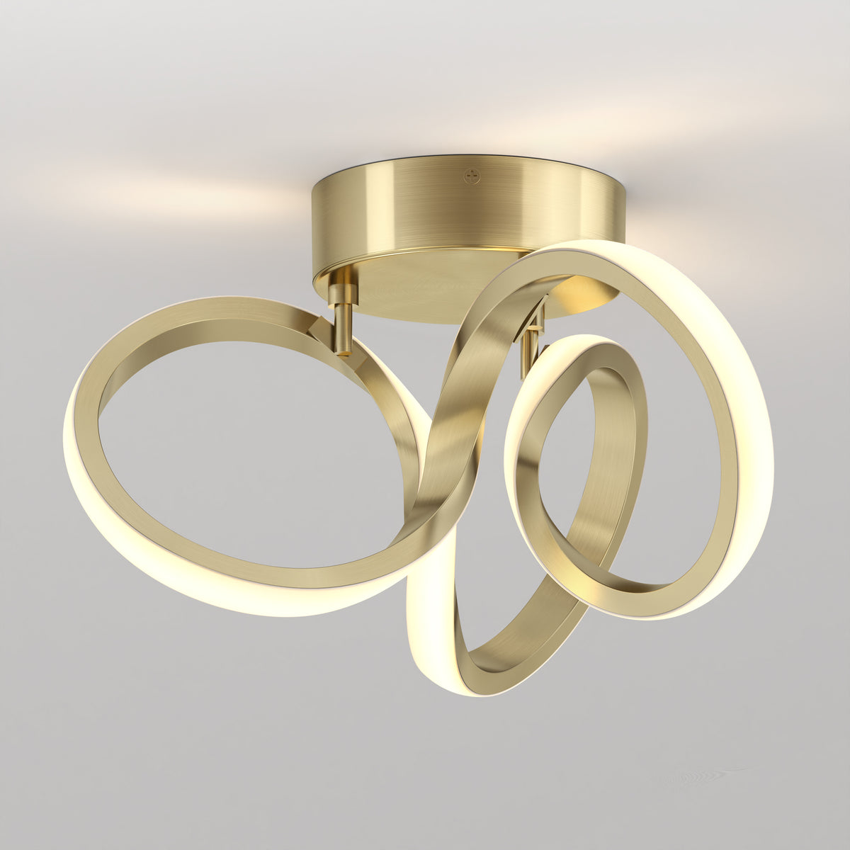 A modern ceiling light fixture with a brushed gold base and three intertwined, illuminated rings creating an abstract, artistic design against a plain white background.