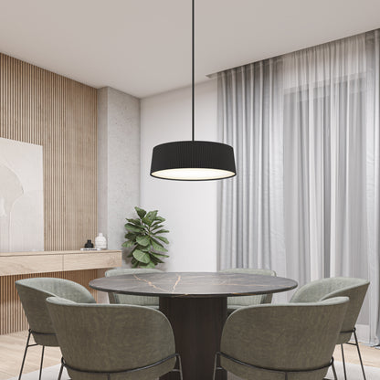 A modern dining area features a round black marble table, four green velvet chairs, the Artika Groove Drum LED contemporary pendant light, light wood paneling, a potted plant, and sheer white curtains over a large window.
