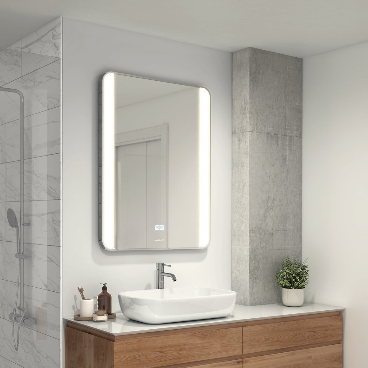 A modern bathroom with a backlit rectangular mirror above a wooden vanity, a white vessel sink, a chrome faucet, and a small potted plant. The shower has a glass door and marble-patterned wall tiles.