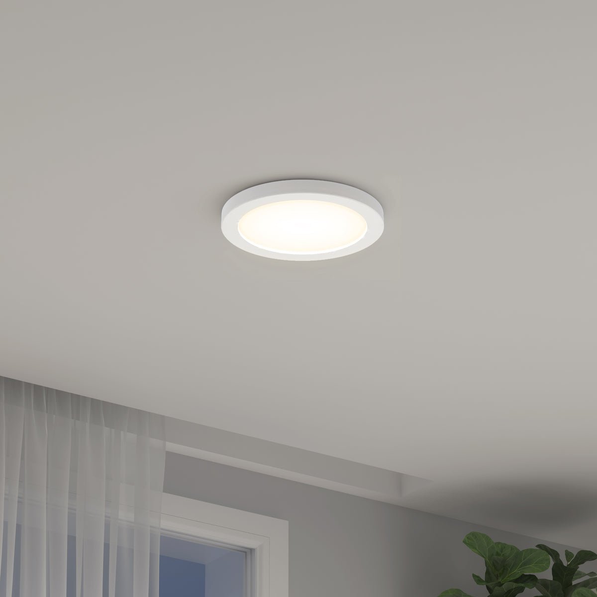 The Artika Europa Disk 7 in. LED modern flush mount light with 3 CCT is shown illuminated on a white ceiling, with a sheer curtain, window, and green leafy plant visible in the lower corners of the room.
