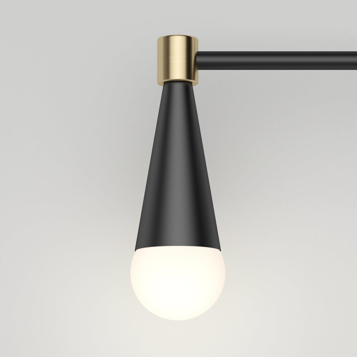 A modern pendant light with a matte black conical shade, brass accents, and a round white bulb, mounted on a horizontal black metal rod against a plain light gray background.