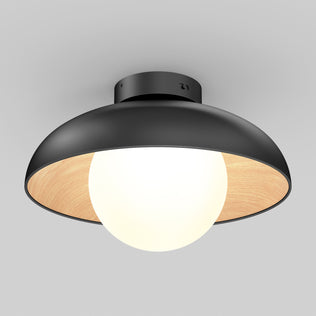 The Artika Boden LED flush mount light 5 CCT features a modern black, dome-shaped shade with a wooden inner lining and a large round white bulb, mounted on a light gray ceiling.
