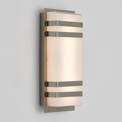 The Artika Glowbox 3 indoor-outdoor LED wall light features a frosted rectangular glass shade with three horizontal metal bands, mounted on a brushed metal plate against a white wall.