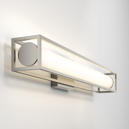 The Artika Venicia LED Wall Sconce features a modern brushed metal rectangular frame and a cylindrical frosted glass tube, elegantly mounted on a white wall.
