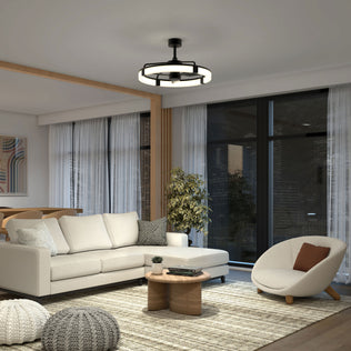 A modern living room features a white sectional sofa, round wooden coffee table, accent chair, large windows with sheer curtains, a potted plant, abstract wall art, and the Artika Sunnyvale 28 in. LED modern ceiling fan with remote control.