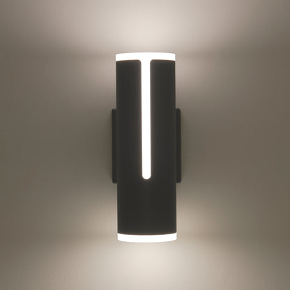The Artika Linea modern indoor-outdoor LED wall light features a cylindrical black design with vertical cutouts, casting soft white light both upward and downward on any wall.